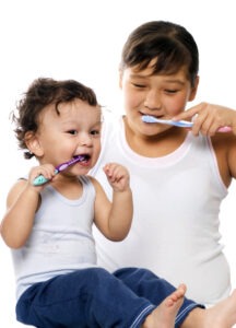 child and baby brushing teeth