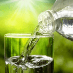 Pouring water from a water bottle into a glass.